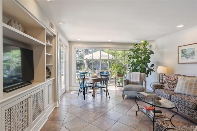 living room with built in shelves and light tile patterned floors