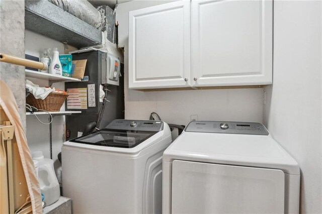 laundry area featuring washing machine and dryer and cabinets