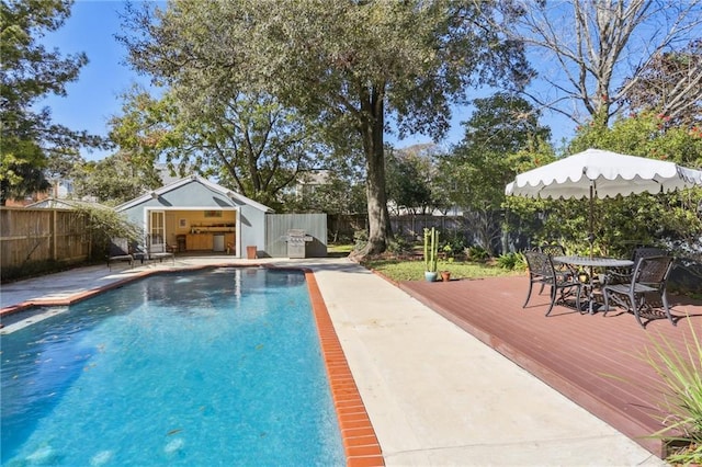 view of swimming pool with a deck and an outbuilding