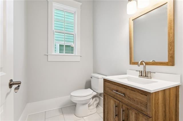 bathroom featuring toilet, vanity, and tile patterned flooring