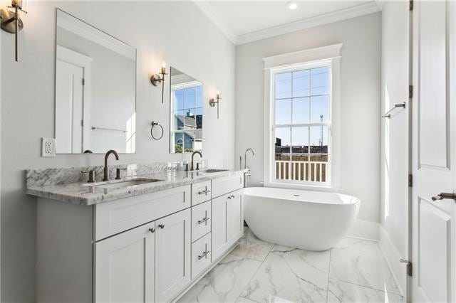 bathroom featuring a tub to relax in, vanity, and crown molding