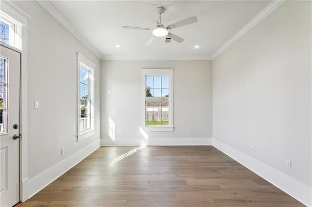 spare room with ceiling fan, a healthy amount of sunlight, hardwood / wood-style floors, and crown molding