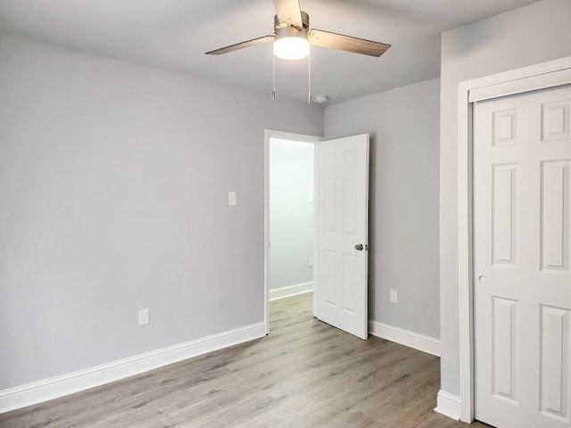 unfurnished bedroom featuring ceiling fan, a closet, and light hardwood / wood-style floors