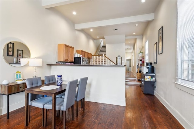 dining space featuring dark hardwood / wood-style floors and beamed ceiling