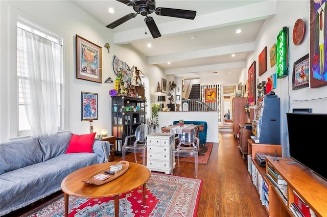 living room with ceiling fan, dark hardwood / wood-style floors, and beamed ceiling