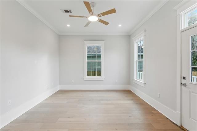 spare room featuring light wood-type flooring, ceiling fan, and crown molding