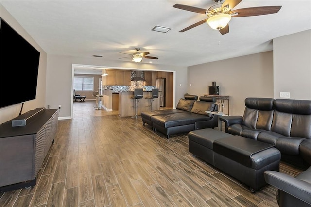 living room featuring hardwood / wood-style flooring and ceiling fan