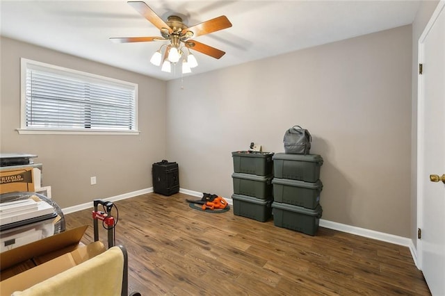 sitting room with dark wood-type flooring and ceiling fan