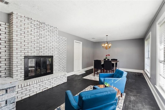 living room featuring a notable chandelier, a fireplace, and a textured ceiling