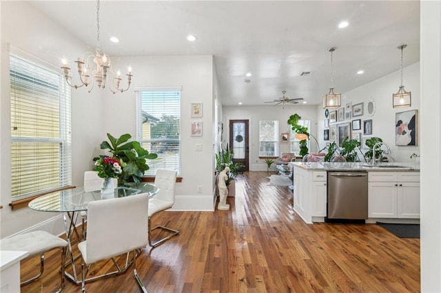 kitchen featuring decorative light fixtures, dishwasher, ceiling fan with notable chandelier, and white cabinetry