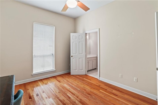 unfurnished bedroom with ensuite bath, light hardwood / wood-style flooring, and ceiling fan