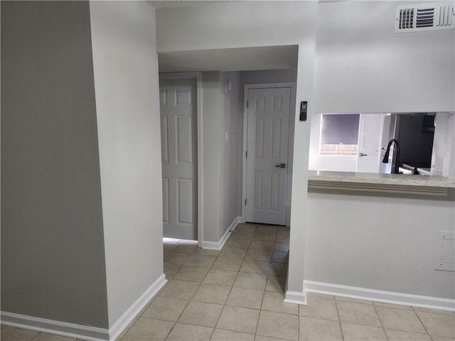 hallway with sink and light tile patterned floors