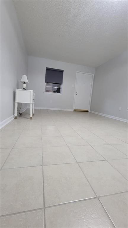 additional living space with a textured ceiling and light tile patterned floors