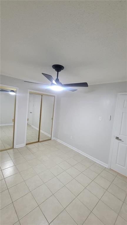 unfurnished bedroom with a closet, ceiling fan, and light tile patterned floors