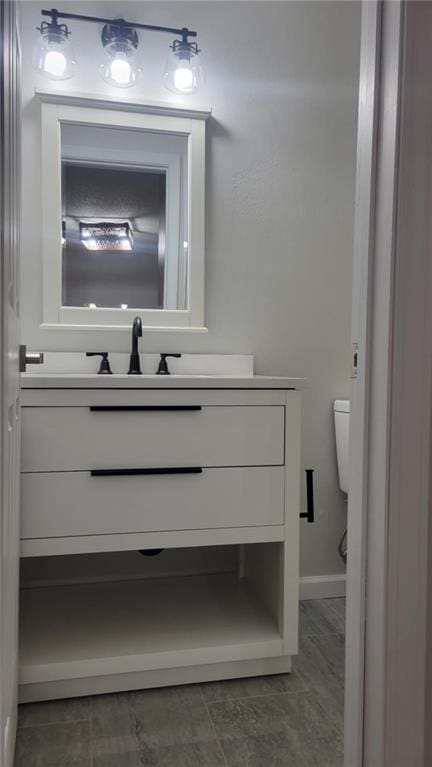 bathroom featuring toilet and vanity