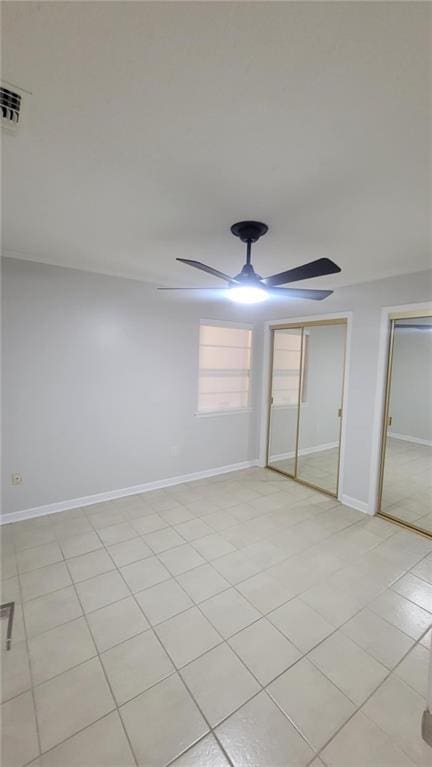 unfurnished bedroom with a closet, light tile patterned floors, and ceiling fan