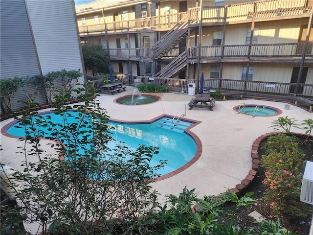 view of pool with a patio area and a hot tub