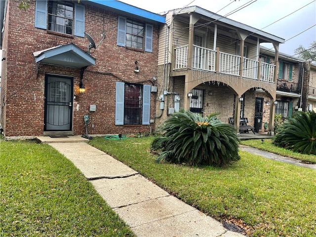 townhome / multi-family property with a front lawn and a balcony