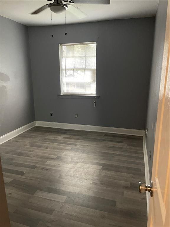 empty room featuring ceiling fan and dark hardwood / wood-style flooring