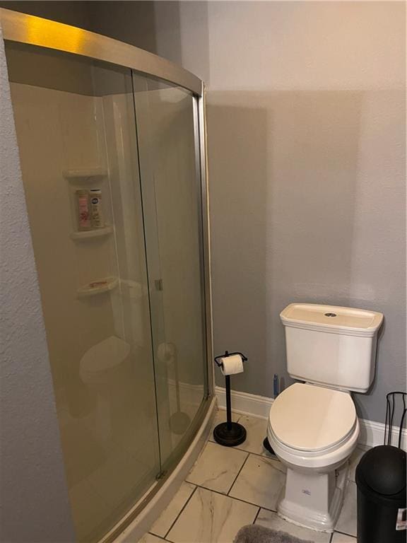 bathroom with a shower with shower door and toilet