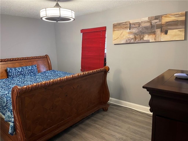 bedroom featuring dark wood-type flooring and a textured ceiling