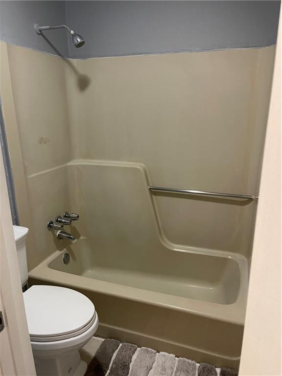 bathroom featuring toilet and shower / bathtub combination