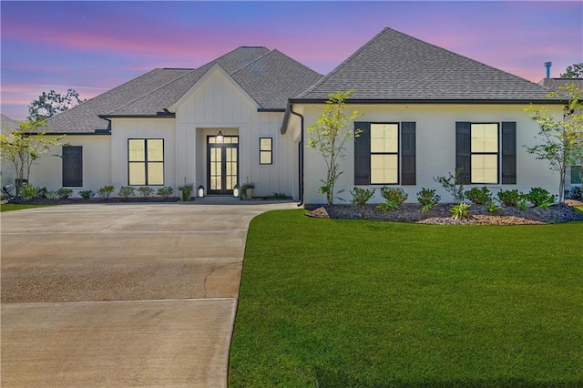 view of front of home featuring a lawn and french doors