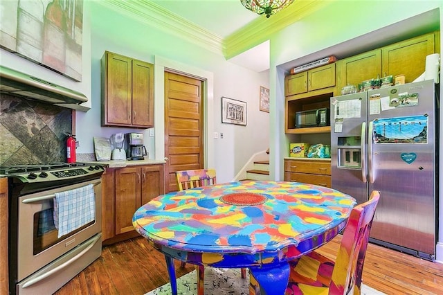 2301 Dauphine St, New Orleans, LA 70117 - kitchen featuring crown molding, stainless steel appliances, dark hardwood / wood-style floors, and decorative backsplash