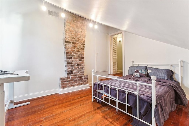 2301 Dauphine St, New Orleans, LA 70117 - bedroom featuring lofted ceiling, wood-type flooring, and track lighting