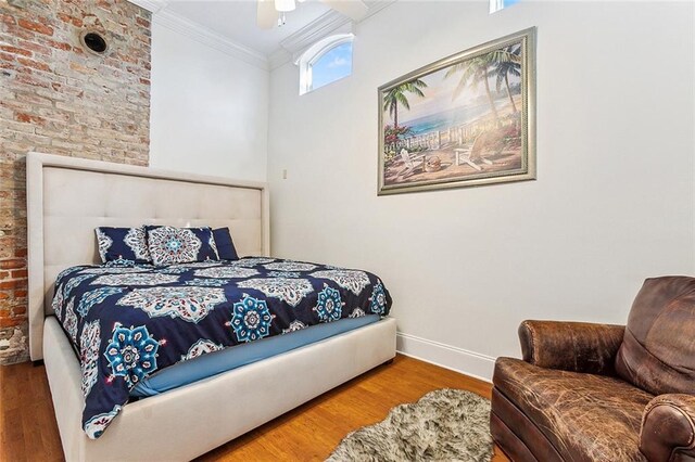 2301 Dauphine St, New Orleans, LA 70117 - bedroom with hardwood / wood-style floors, crown molding, ceiling fan, and brick wall