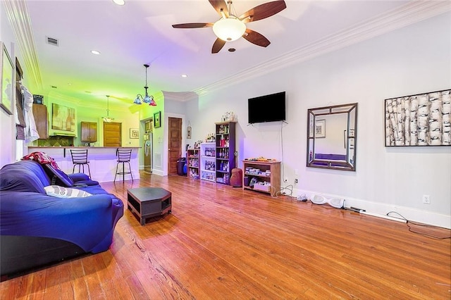 living room with crown molding, ceiling fan, and hardwood / wood-style flooring