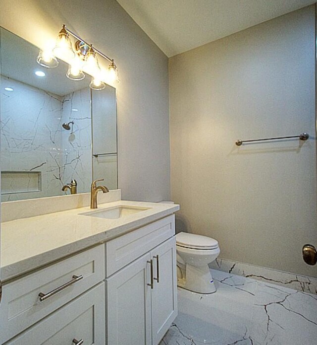 bathroom featuring toilet, a shower, and vanity