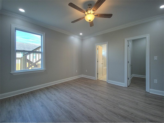 unfurnished bedroom featuring a spacious closet, ensuite bathroom, hardwood / wood-style floors, ceiling fan, and ornamental molding