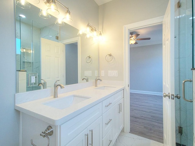 bathroom with a shower with shower door, vanity, and ceiling fan