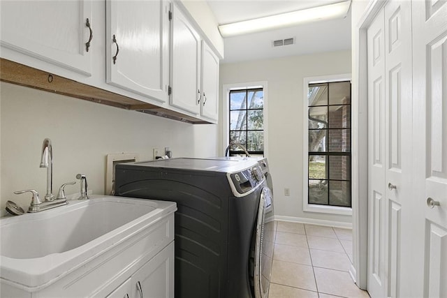 laundry room with cabinets, sink, washer and clothes dryer, and light tile patterned floors