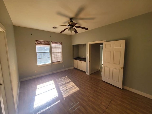 unfurnished bedroom featuring dark wood-type flooring and ceiling fan