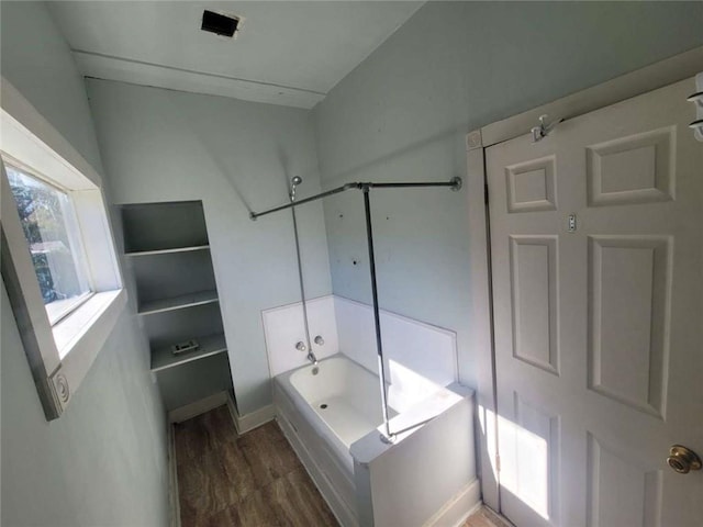 bathroom with wood-type flooring and bathing tub / shower combination