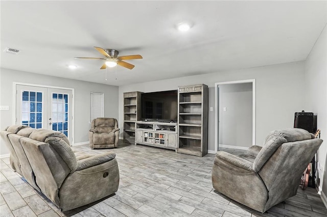 living room featuring ceiling fan, light hardwood / wood-style flooring, and french doors