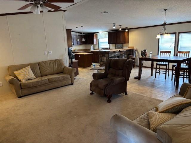 169 Pump Station Rd, Venice, LA 70091 - living room with ceiling fan with notable chandelier and a textured ceiling