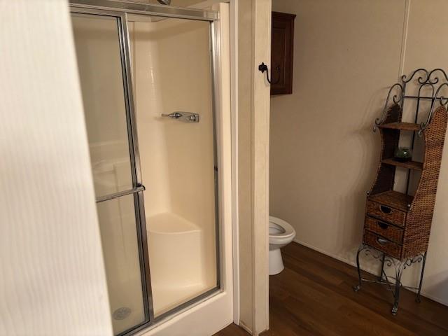 169 Pump Station Rd, Venice, LA 70091 - bathroom with wood-type flooring, toilet, and walk in shower