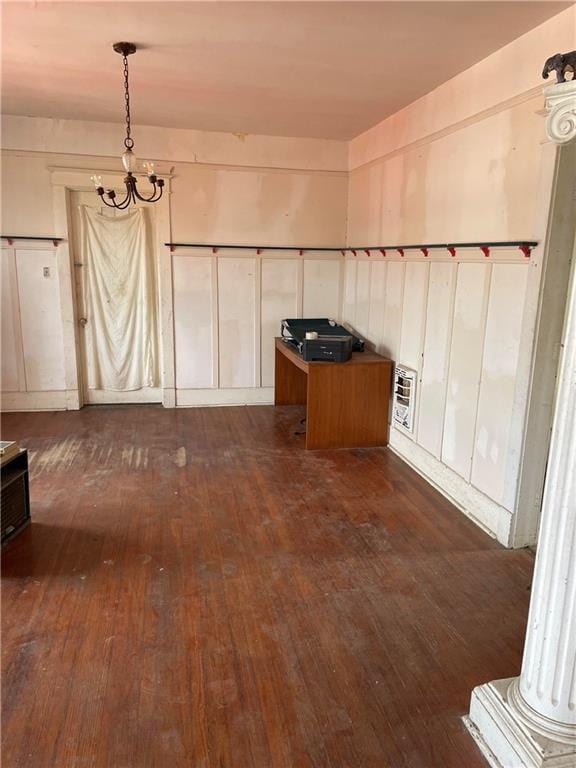 unfurnished dining area featuring an inviting chandelier and dark hardwood / wood-style floors