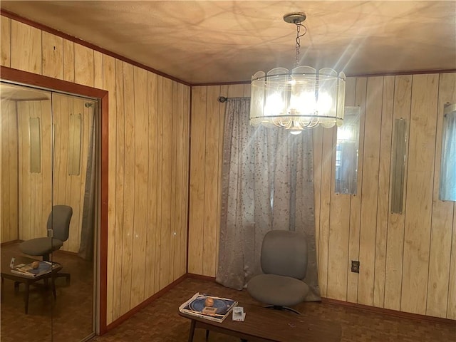 unfurnished room featuring a chandelier and wooden walls