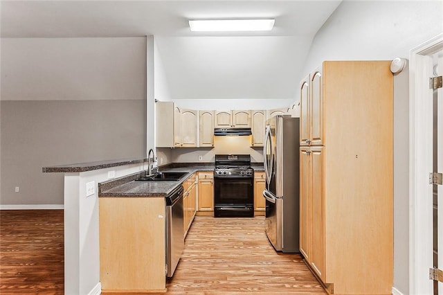 kitchen with kitchen peninsula, stainless steel appliances, vaulted ceiling, light hardwood / wood-style flooring, and sink