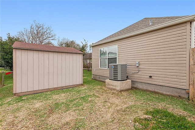 exterior space with central AC unit, a shed, and a yard