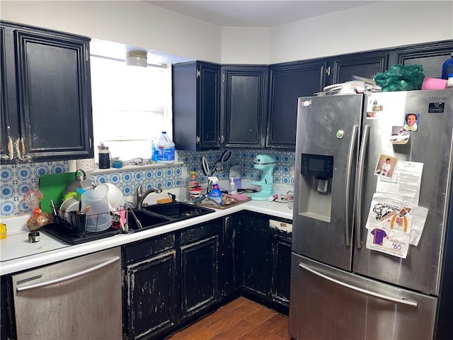 kitchen featuring dark wood-type flooring, decorative backsplash, appliances with stainless steel finishes, and sink