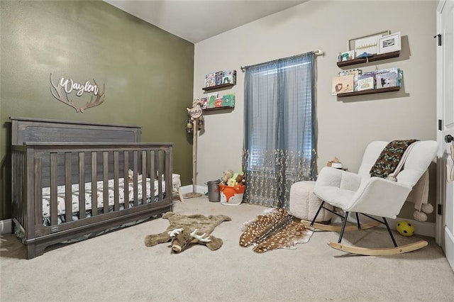 carpeted bedroom featuring a nursery area