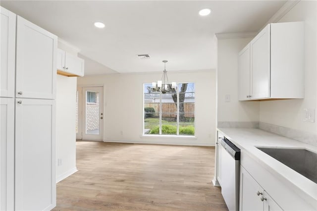 kitchen featuring dishwasher, light countertops, hanging light fixtures, and white cabinetry