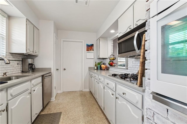 kitchen featuring sink, white cabinetry, stainless steel appliances, and a healthy amount of sunlight