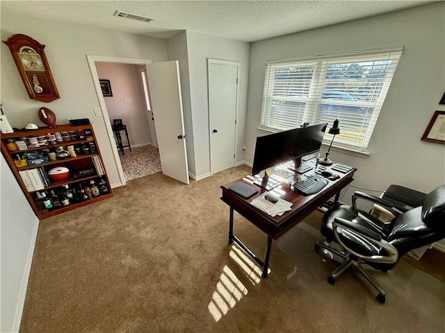 carpeted office featuring a textured ceiling