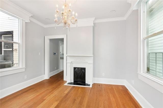 unfurnished living room featuring light wood-type flooring and ornamental molding